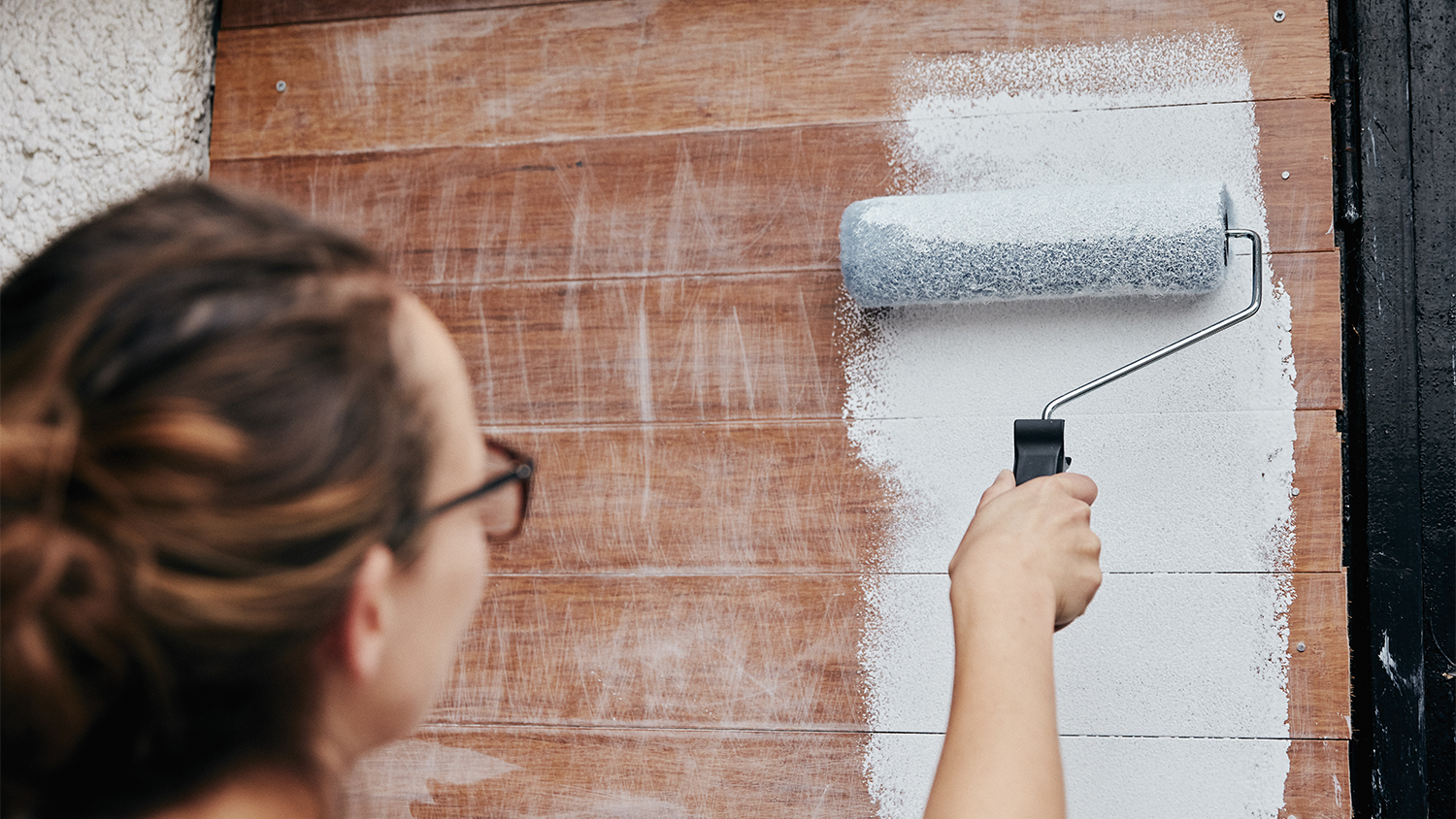 woman painting wooden planks white